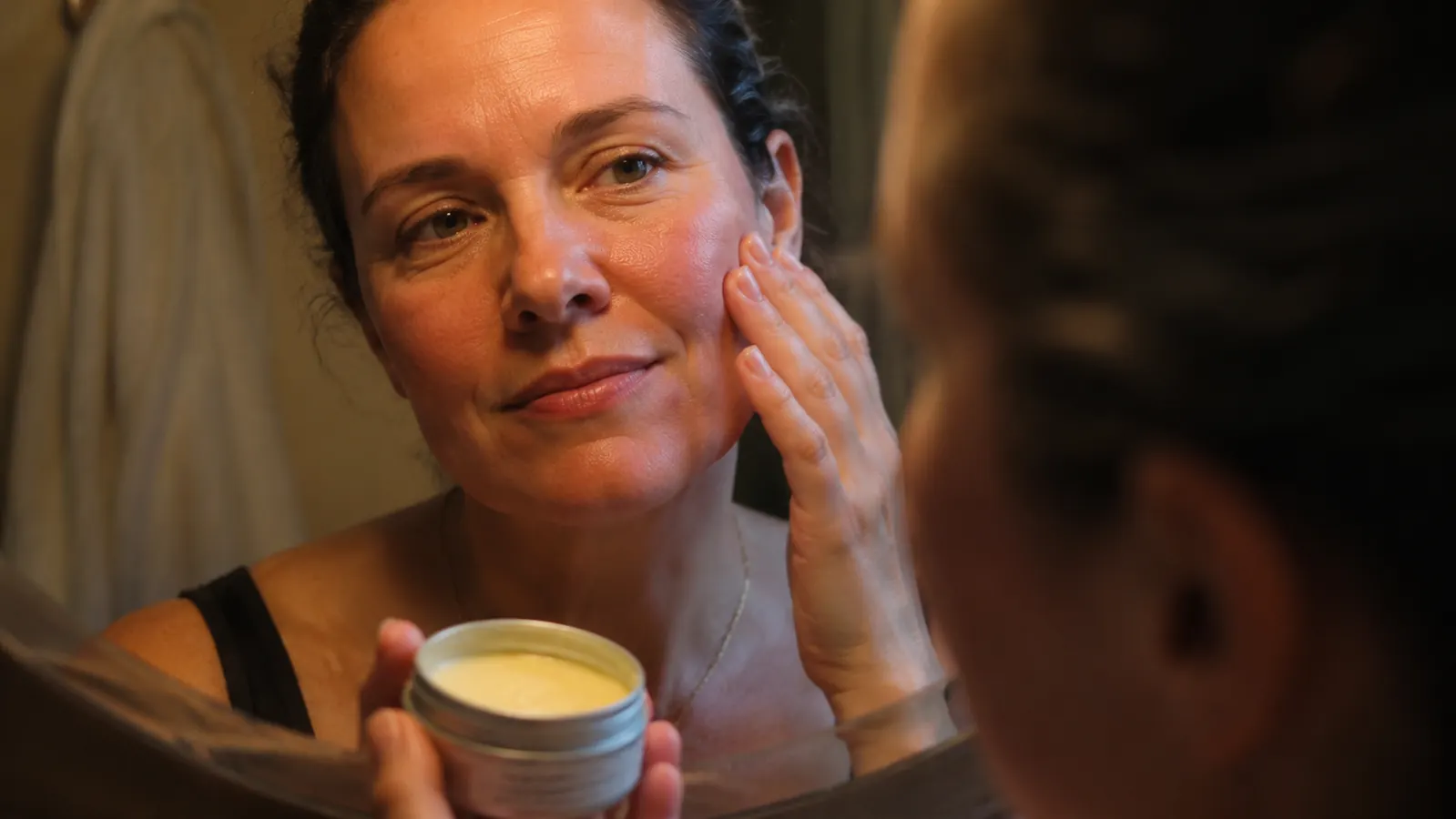 JUNO & Co. Clean 10 Cleansing Balm tin open on a bathroom counter in warm evening light